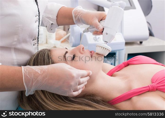 Woman having a facial massage and peeling in beauty salon