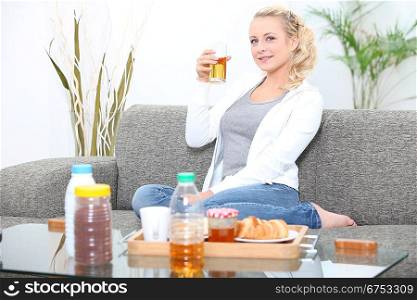 Woman having breakfast in her living room