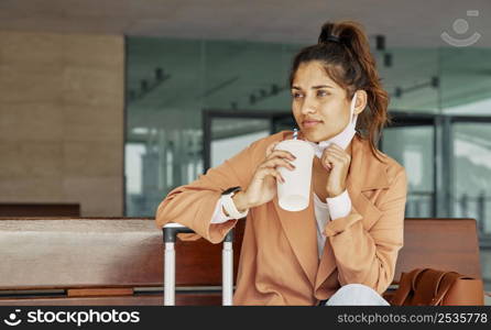 woman having coffee airport during pandemic