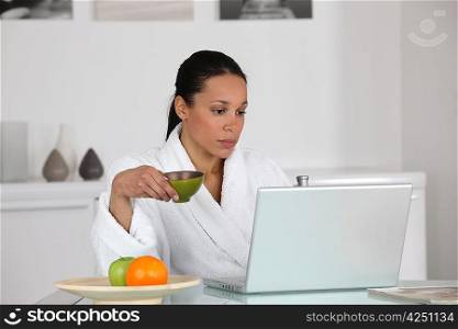 Woman having coffee at home in dressing gown