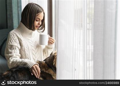 woman having cup coffee window home during pandemic
