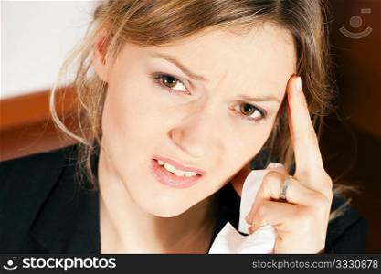Woman having headache and feeling unwell, holding her head in her hand