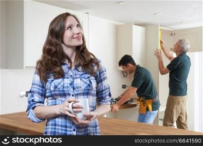 Woman Having New Kitchen Fitted Drinking Cup Of Coffee