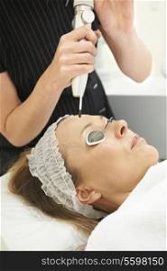 Woman Having Skin Rejuvenating Laser Treatment In Clinic
