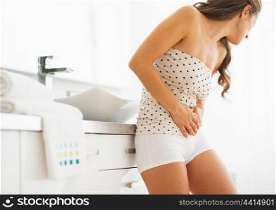 Woman having stomachache in bathroom