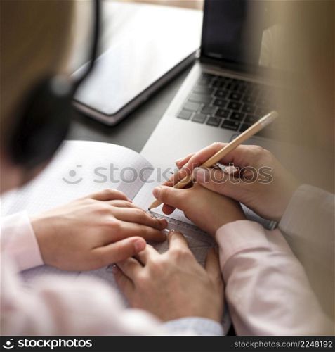 woman helping girl doing her homework