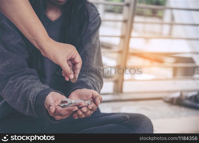 Woman helping hands to homeless people poverty beggar man holding hands asking for money job and hoping help in helpless dirty city sitting on streets. Desperate Beggar in city concept.