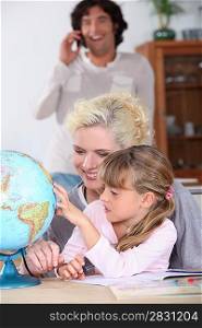 Woman helping her daughter complete her geography homework