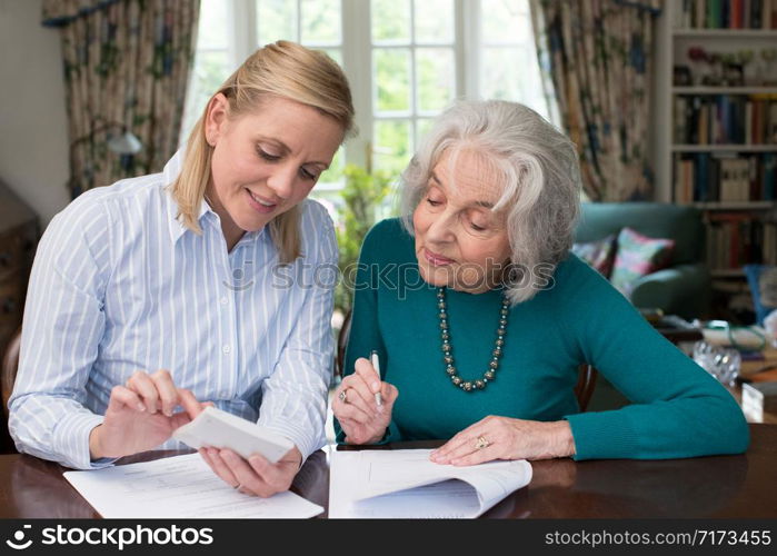 Woman Helping Senior Neighbor With Paperwork