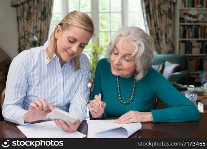 Woman Helping Senior Neighbor With Paperwork