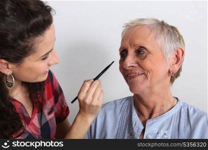 Woman helping to apply make-up