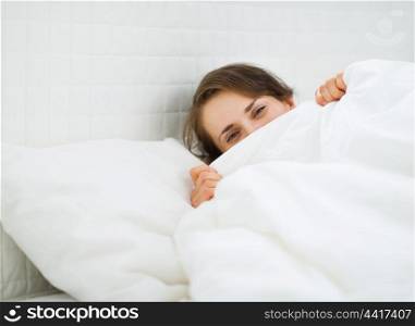 Woman hiding behind blanket