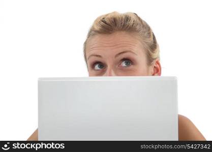 Woman hiding behind laptop