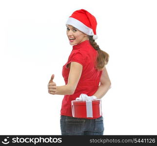 Woman hiding Christmas present behind back and showing thumbs up