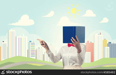 Woman hiding face behind book. Woman with opened book against her face pointing with finger