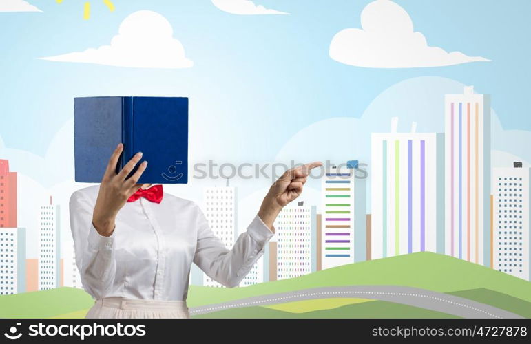 Woman hiding face behind book. Woman with opened book against her face pointing with finger