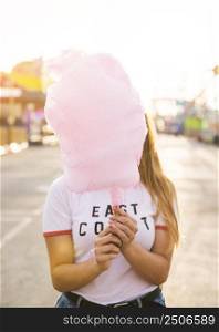 woman hiding her face front pink candy floss