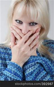 woman hiding her mouth with her hands .