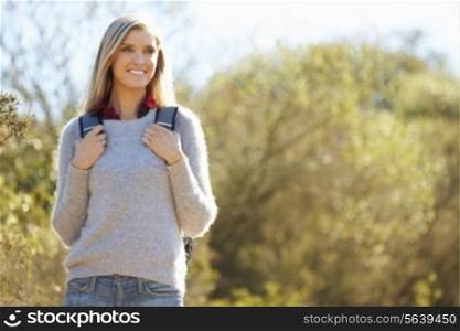 Woman Hiking In Countryside Wearing Backpack