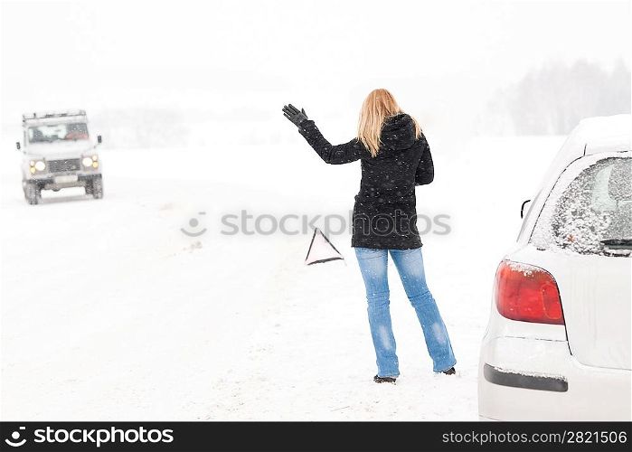 Woman hitchhiking having trouble with car snow winter assistance broken