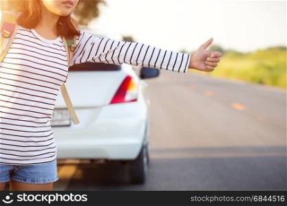 woman hitchhiking looking for help with her broken car on the road. woman hitchhiking looking for help with her broken car on the ro