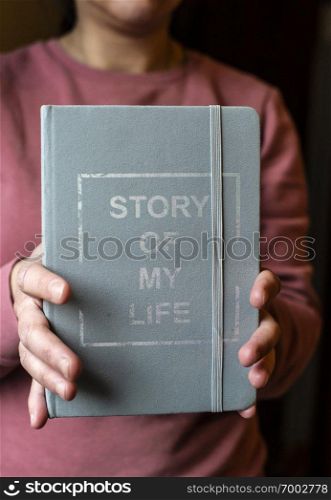 Woman hold notebook. Book notes for the Story of my life. Personal memoirs notes concept. Hands hold book.