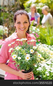 Woman hold potted daisy white flower at garden shopping center