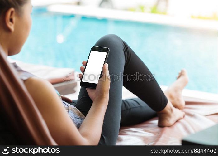 woman holdind and looking on phone take relexing at swiming pool