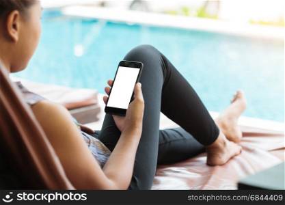woman holdind and looking on phone take relexing at swiming pool