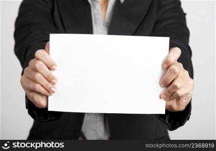 Woman holding a blank paper sheet with both hands