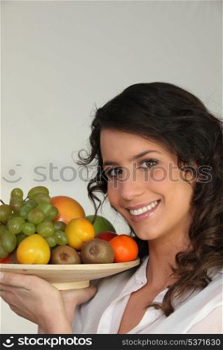 Woman holding a bowl of fruit