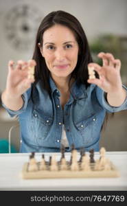 woman holding a chess piece in each hand