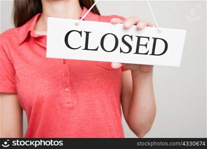 Woman holding a closed sign