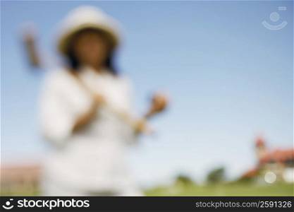 Woman holding a croquet mallet and a ball