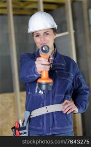woman holding a drill indoors
