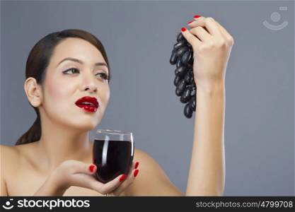 Woman holding a glass of wine and grapes