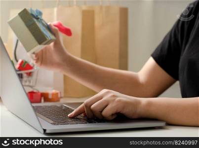 woman holding a green gift box who are shopping online in online shopping concept