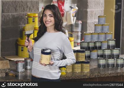 Woman holding a paint can in a hardware store