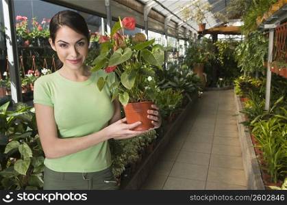 Woman holding a potted plant in a garden center