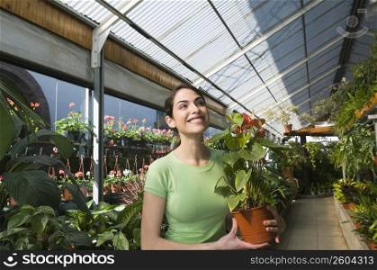 Woman holding a potted plant in a garden center