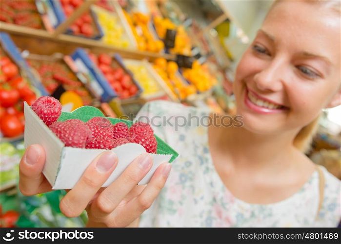 Woman holding a punnet of raspberries