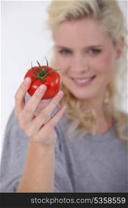 Woman holding a ripe tomato