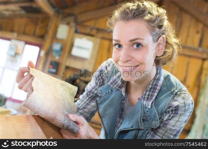 woman holding a sanding paper with wood