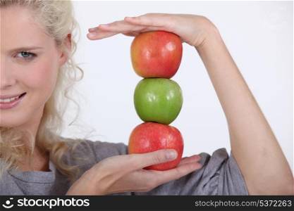 Woman holding a stack of apples