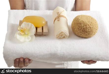 Woman holding a towel with bath products