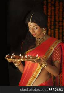Woman holding a tray of diyas