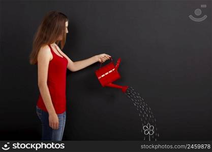 Woman holding a watering can in front of a chalkboard with a flowers and water drops design