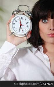 Woman holding alarm clock