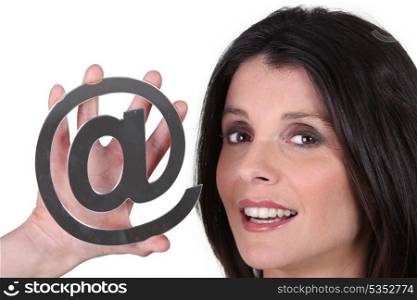 Woman holding an @ sign