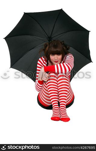 Woman holding an umbrella and dressed in clothing with a red stripe pattern